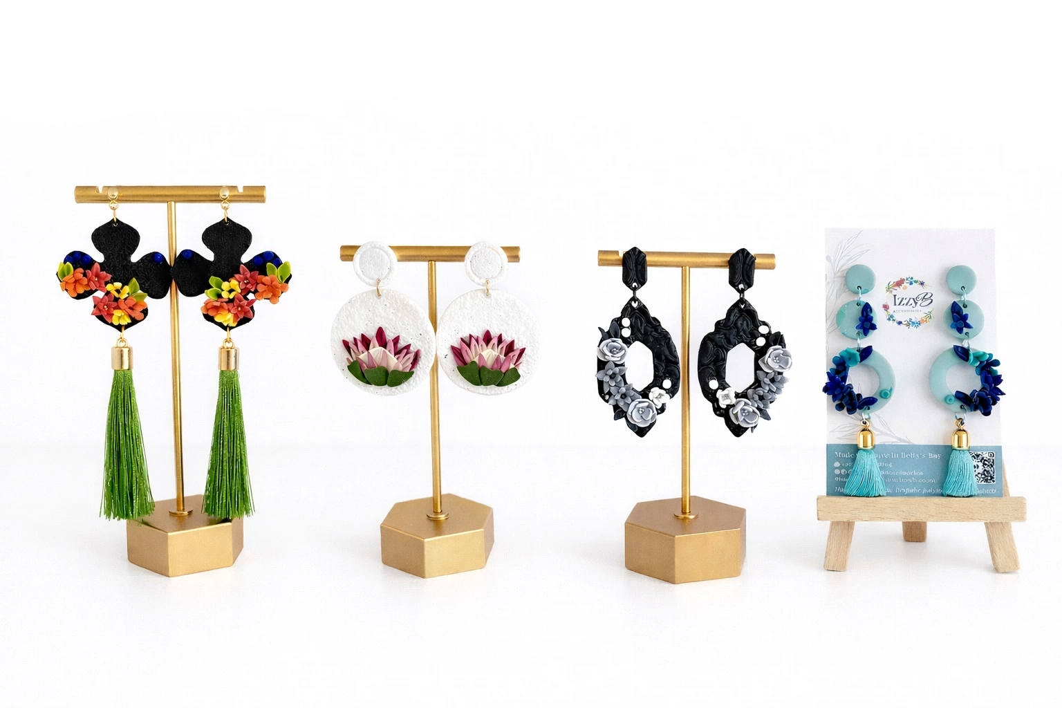 Four decorative statement earring sets displayed on gold jewelry stands